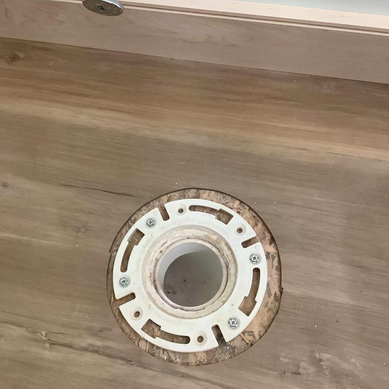 Toilet flange installed in wood subfloor hole Toilet flange installed in wood subfloor hole