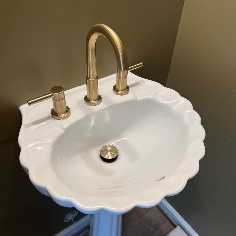 Pedestal sink with gold faucet and drain stopper Pedestal sink with gold faucet and drain stopper