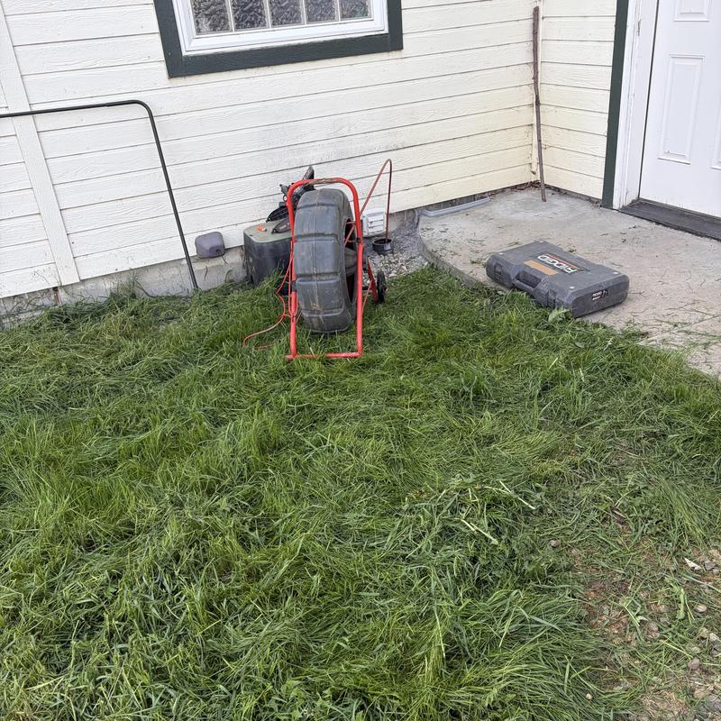 Laundry drain inspection snake and tools on grass outside