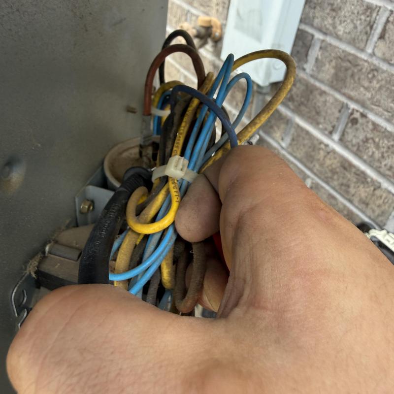 HVAC wiring bundle with technician hand adjusting wires HVAC wiring bundle with technician hand adjusting wires