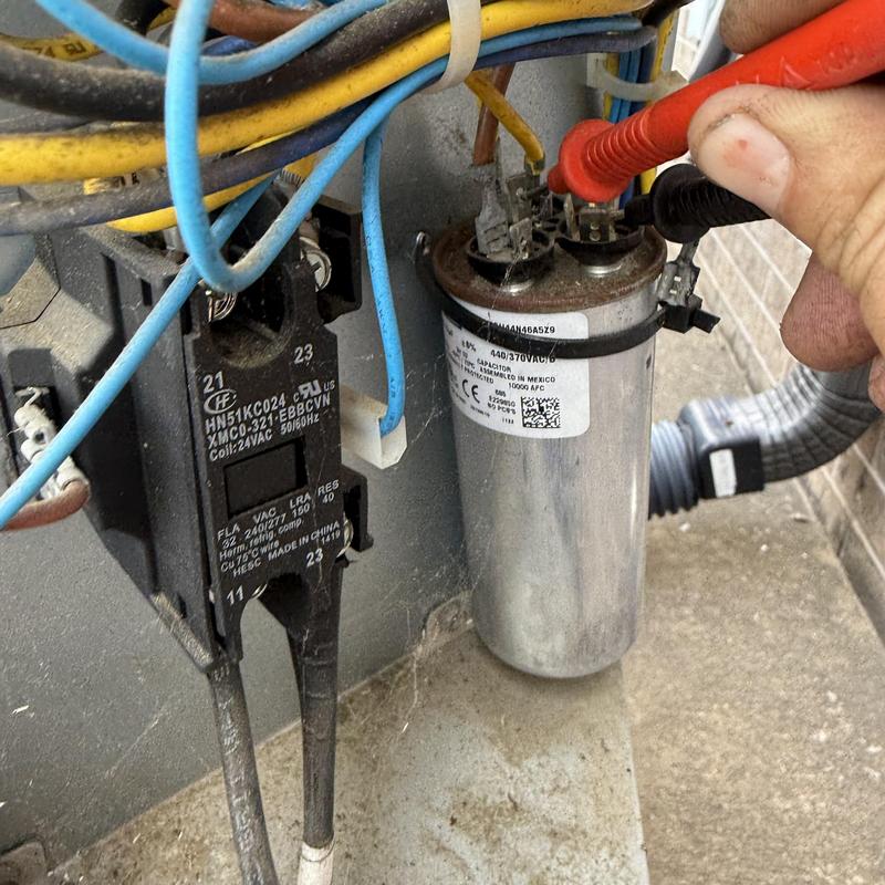 AC capacitor testing with multimeter probes in HVAC unit AC capacitor testing with multimeter probes in HVAC unit