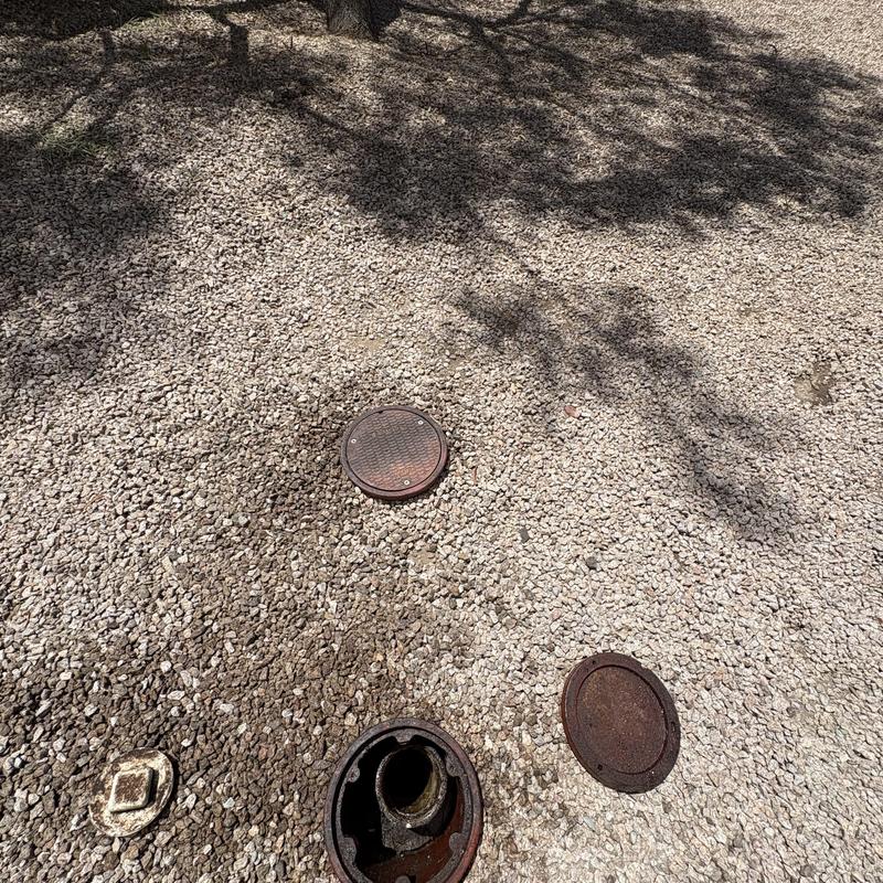 Drain line cleanout covers on gravel surface Drain line cleanout covers on gravel surface