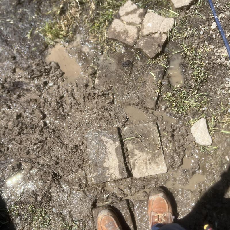 Irrigation piping leak with muddy backyard and pavers