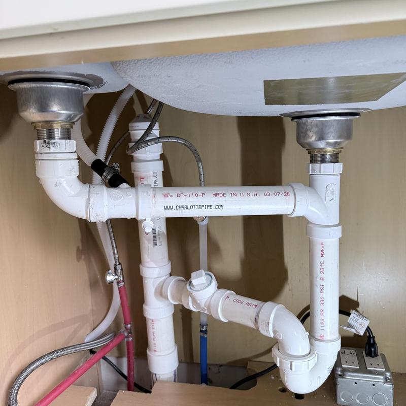 Dual sink PVC drain and trap piping under cabinet Dual sink PVC drain and trap piping under cabinet