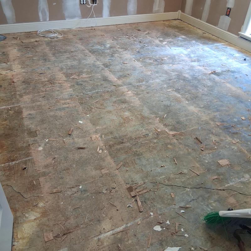 Hardwood flooring subfloor with debris in room