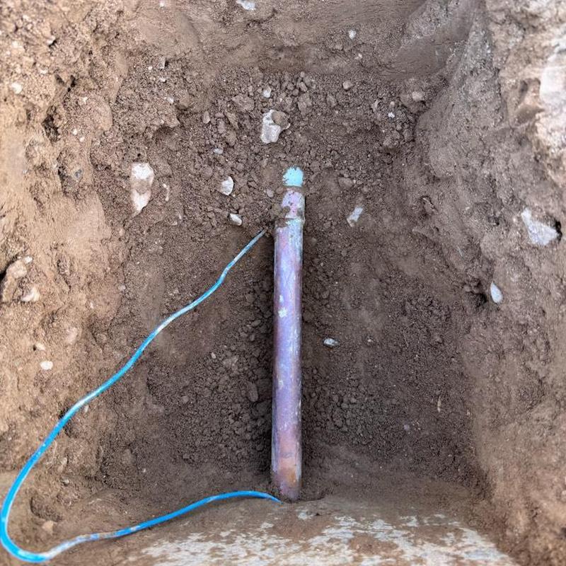 Copper water main in ground with valve pipe exposed