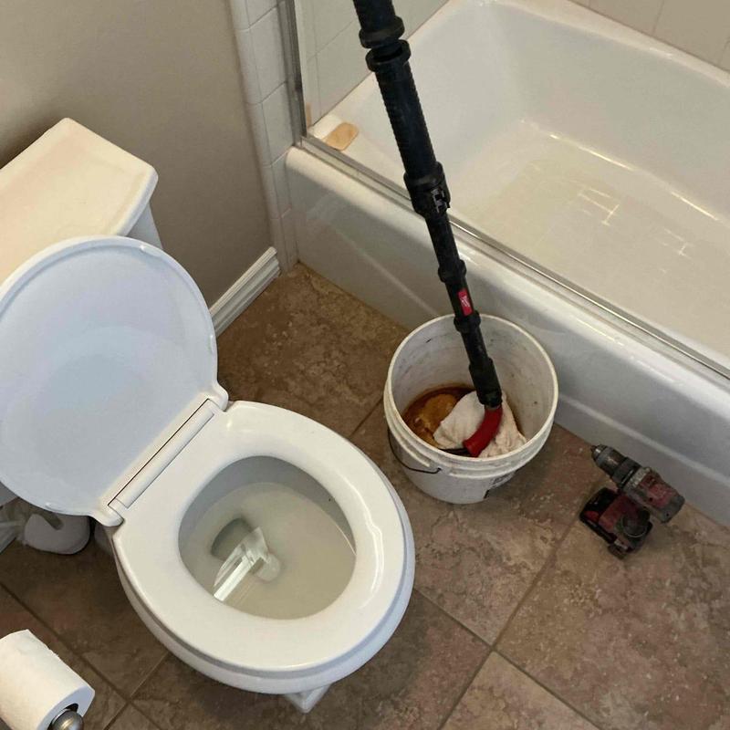 Toilet blockage clearing with auger in bathroom