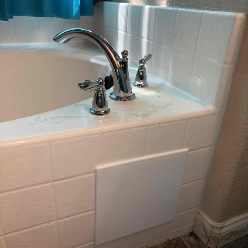 Bathtub faucet and handles on tiled surround