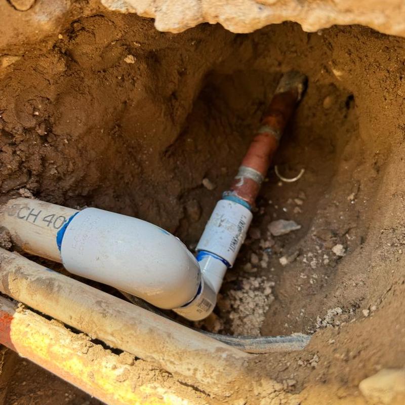 PVC to copper irrigation line fitting in soil trench