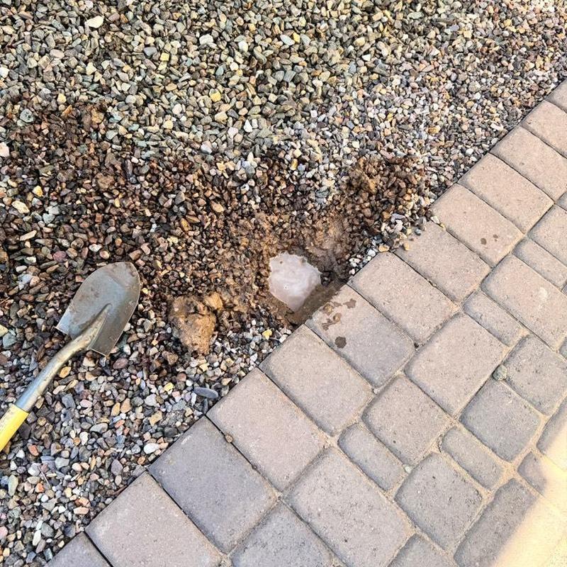 Irrigation line leak at gravel and patio edge