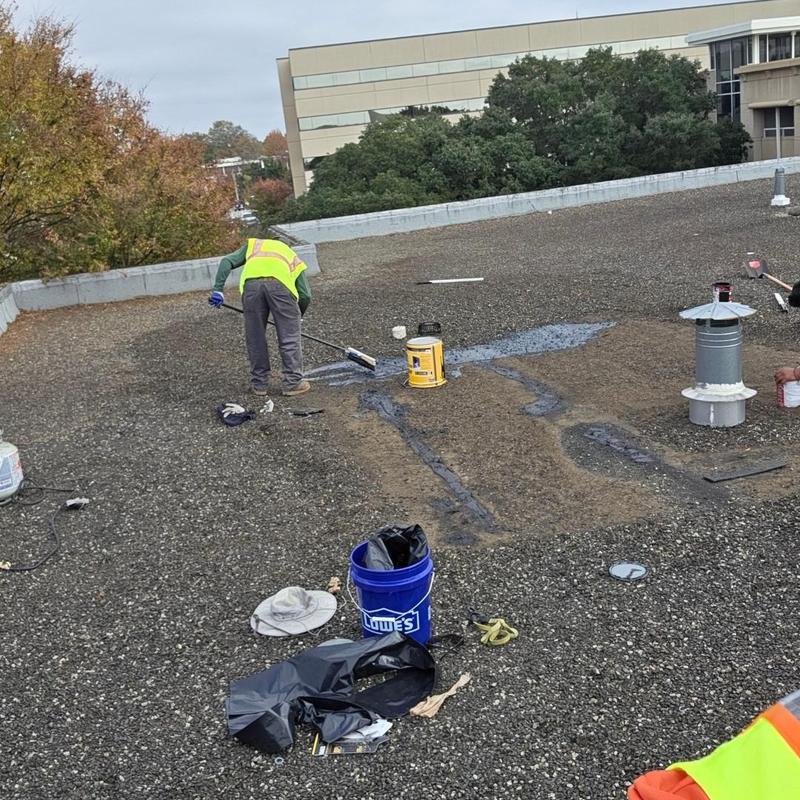 Flat roof patching with tar application on office building Flat roof patching with tar application on office building