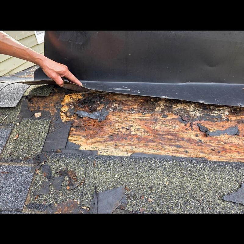 Chimney flashing with dry rot and damaged roof shingles Chimney flashing with dry rot and damaged roof shingles