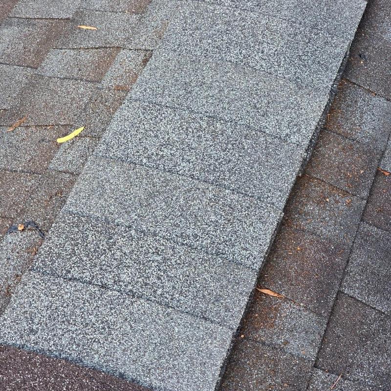 Asphalt roof shingles showing storm damage effects Asphalt roof shingles showing storm damage effects