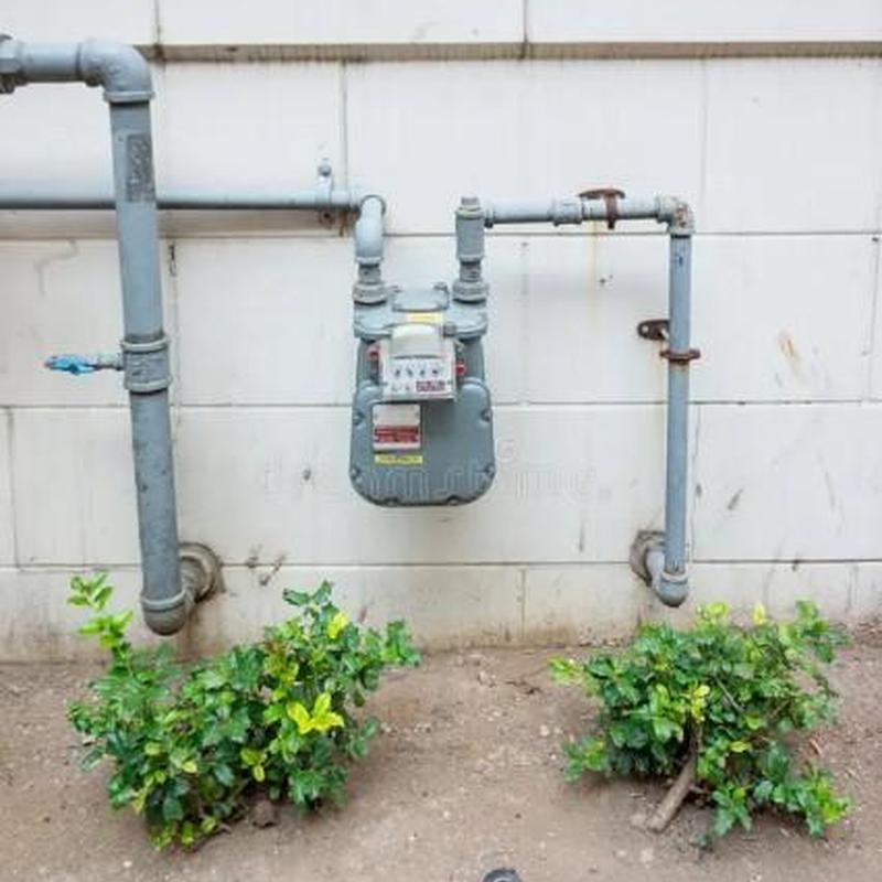 Gas meter with riser pipes on commercial building wall