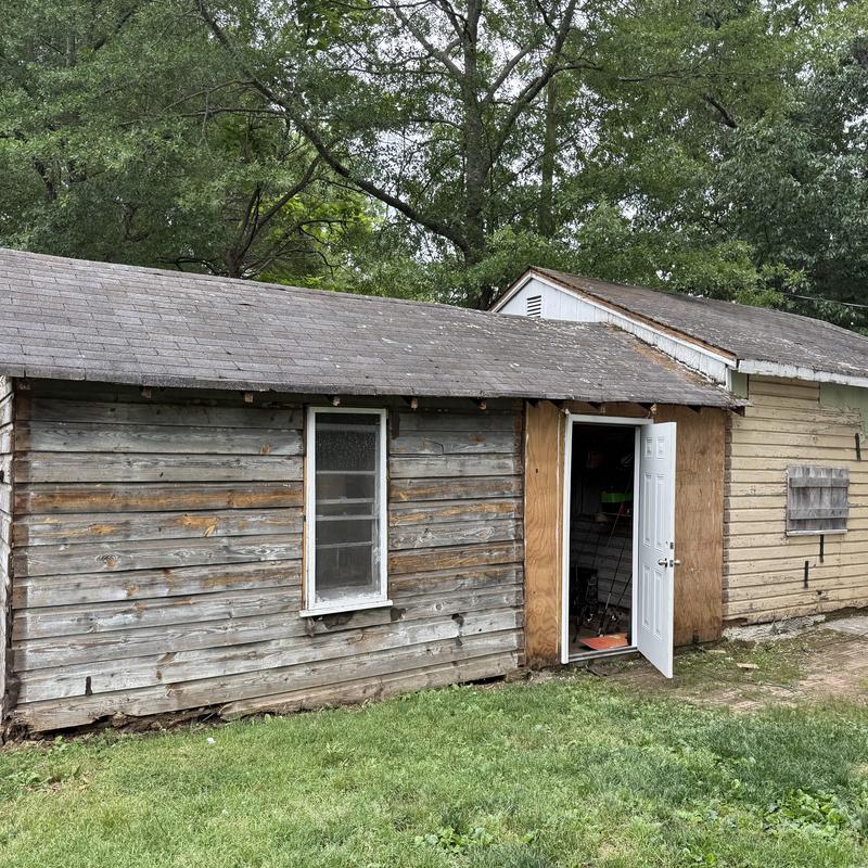 Asphalt shingle roof on weathered wooden outbuilding