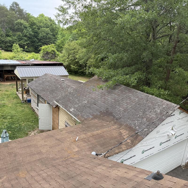 Architectural shingle roof with visible wear and damage