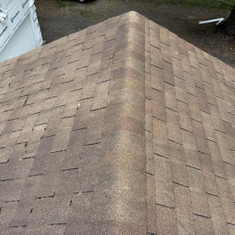 Architectural shingles on roofing ridge on farmhouse roof
