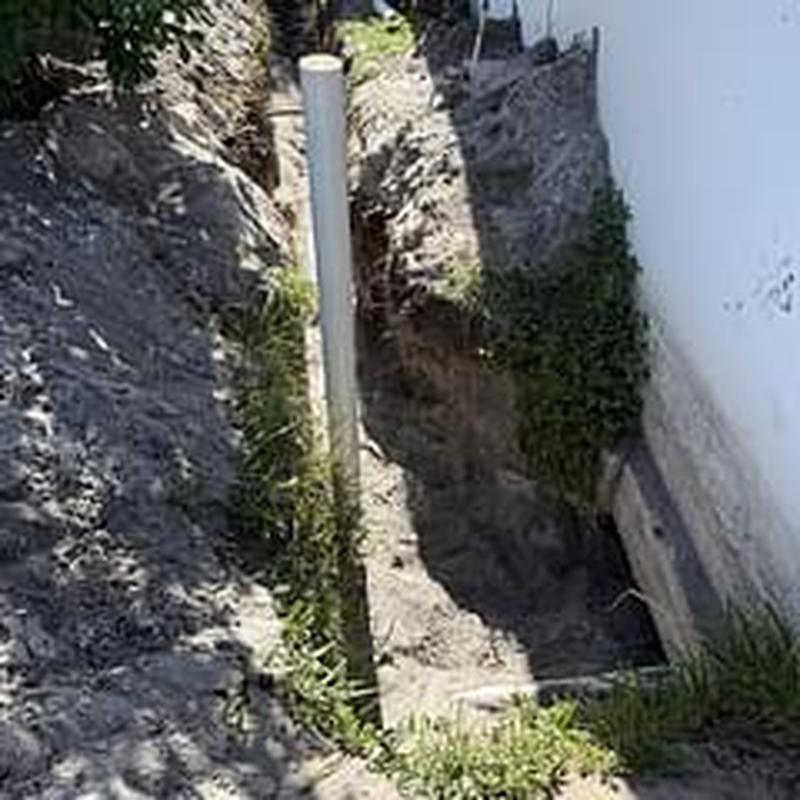 Sewer line installation trench beside foundation wall Sewer line installation trench beside foundation wall