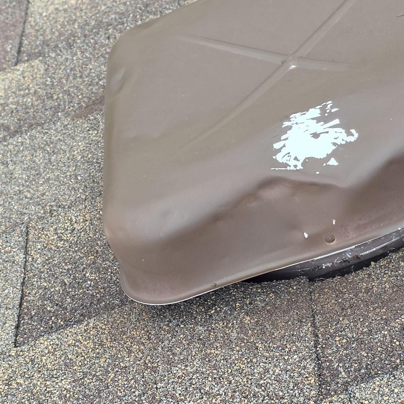 Metal roof vent with hail damage dents and paint chips