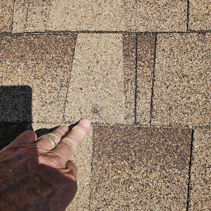 Asphalt roof shingles with hail damage close-up