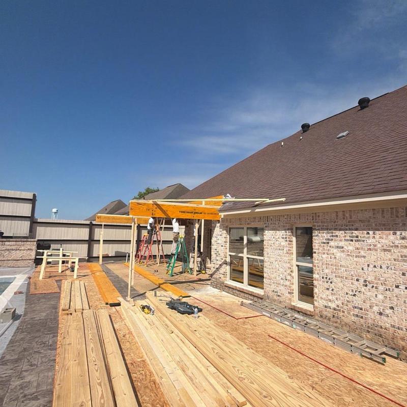 Outdoor kitchen roof framing with lumber and ladders