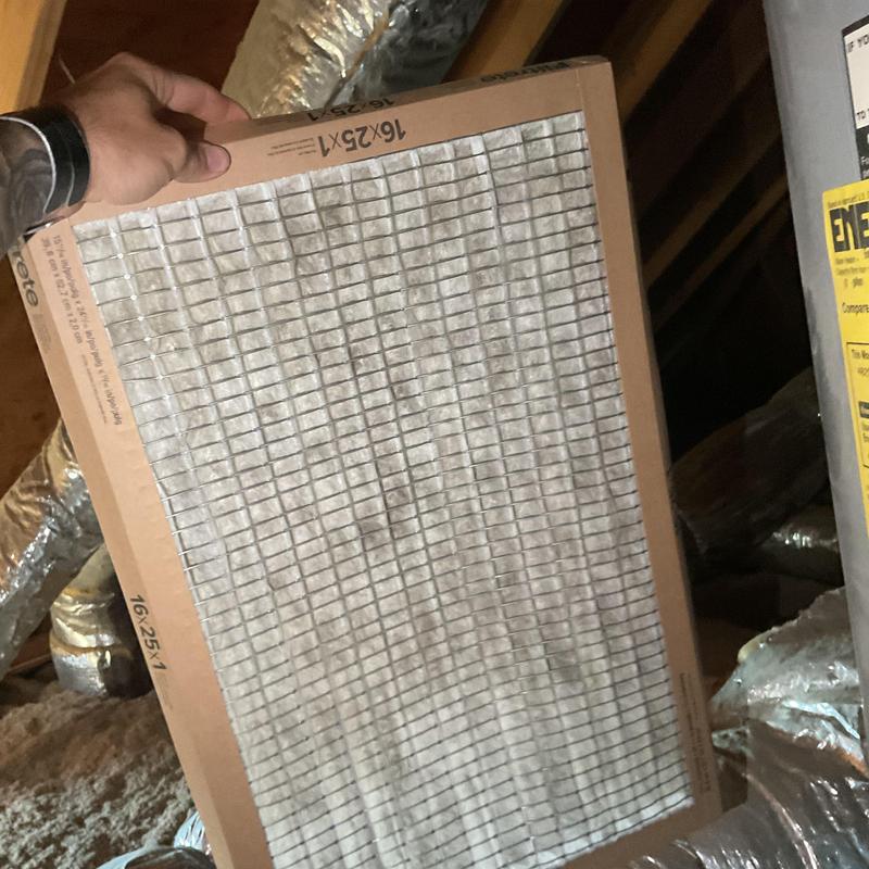 HVAC air filter held for replacement in attic space