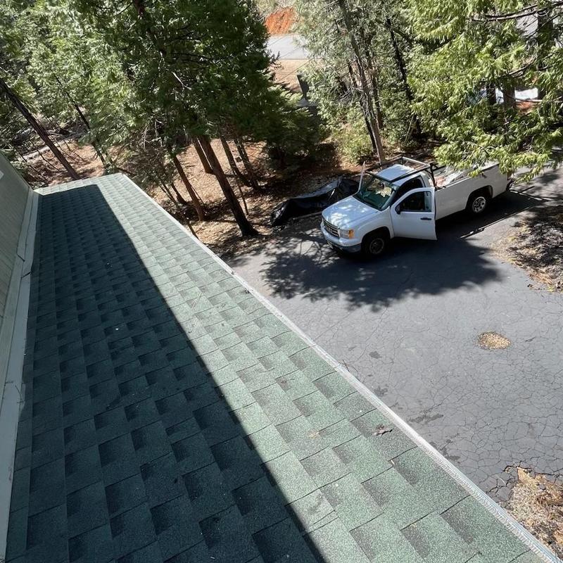Steel seamless gutters with leaf blaster guards on cabin roof