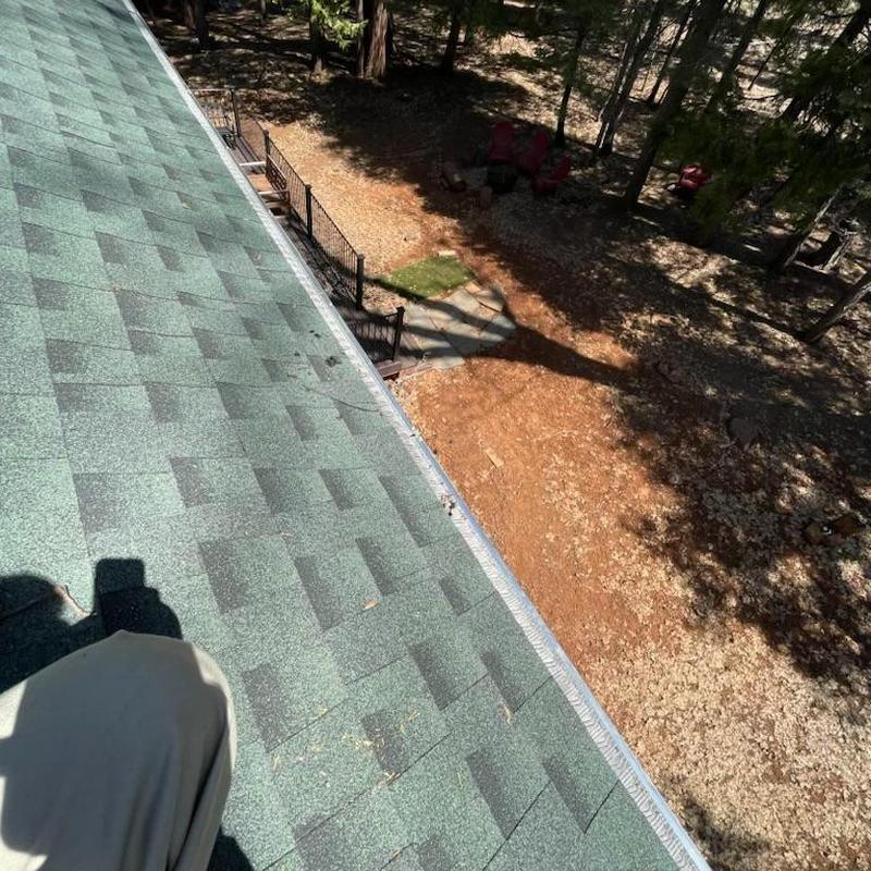 Steel seamless gutters with leaf blaster guards on cabin roof