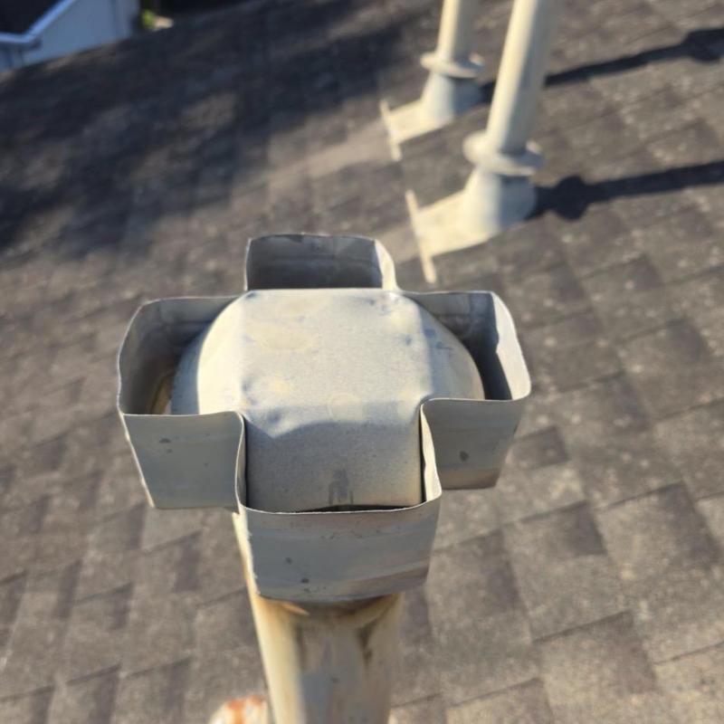 Metal roof vent pipe with protective collar on shingle roof Metal roof vent pipe with protective collar on shingle roof
