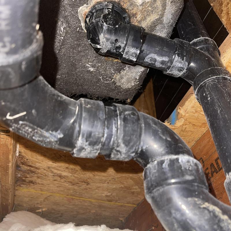 Bathtub drain spud and black PVC plumbing pipes