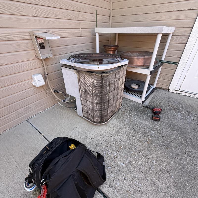Condenser unit with dirty fins near patio shelf