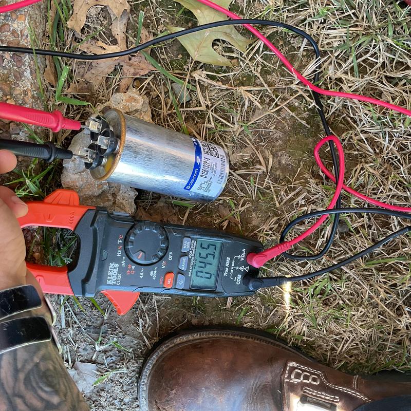 AC capacitor electrical testing with clamp meter outdoors