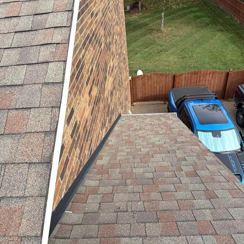 Asphalt shingle roof with metal flashing and hail damage