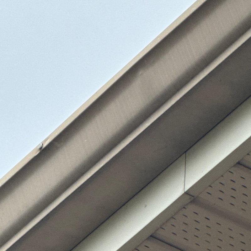 Roof flashing with hail damage on church roof edge