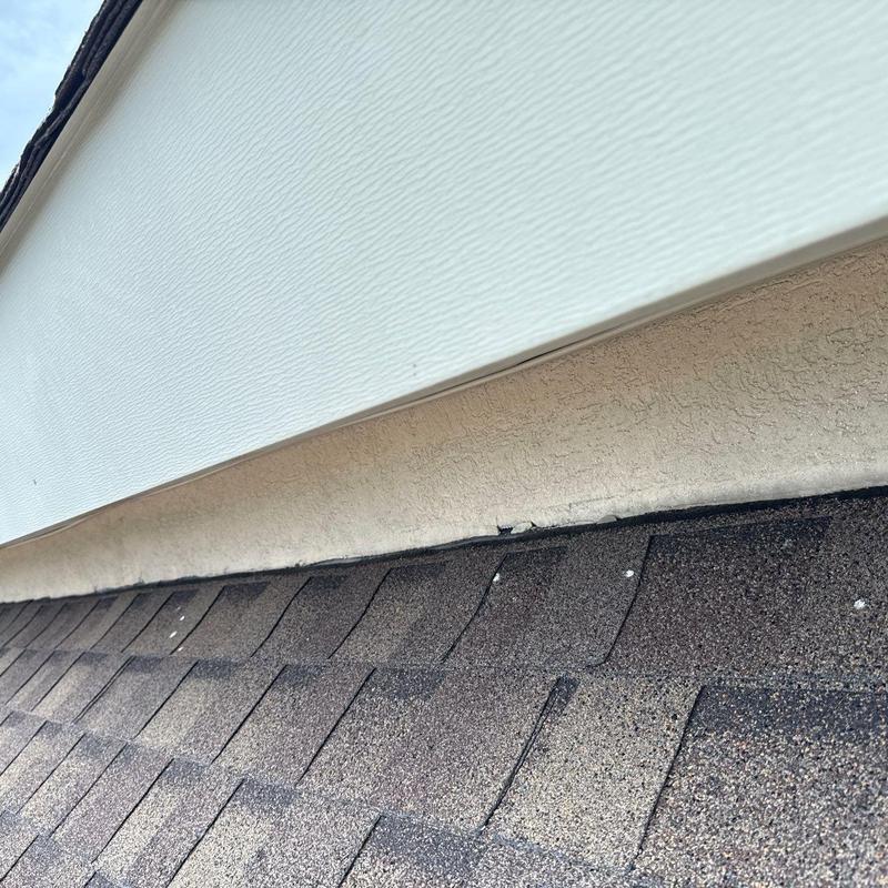 Roof shingles with hail damage near soffit flashing