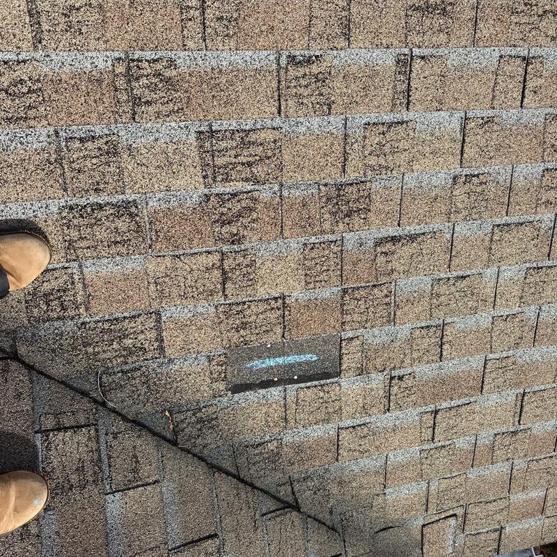 Asphalt roof shingles with marked hail damage