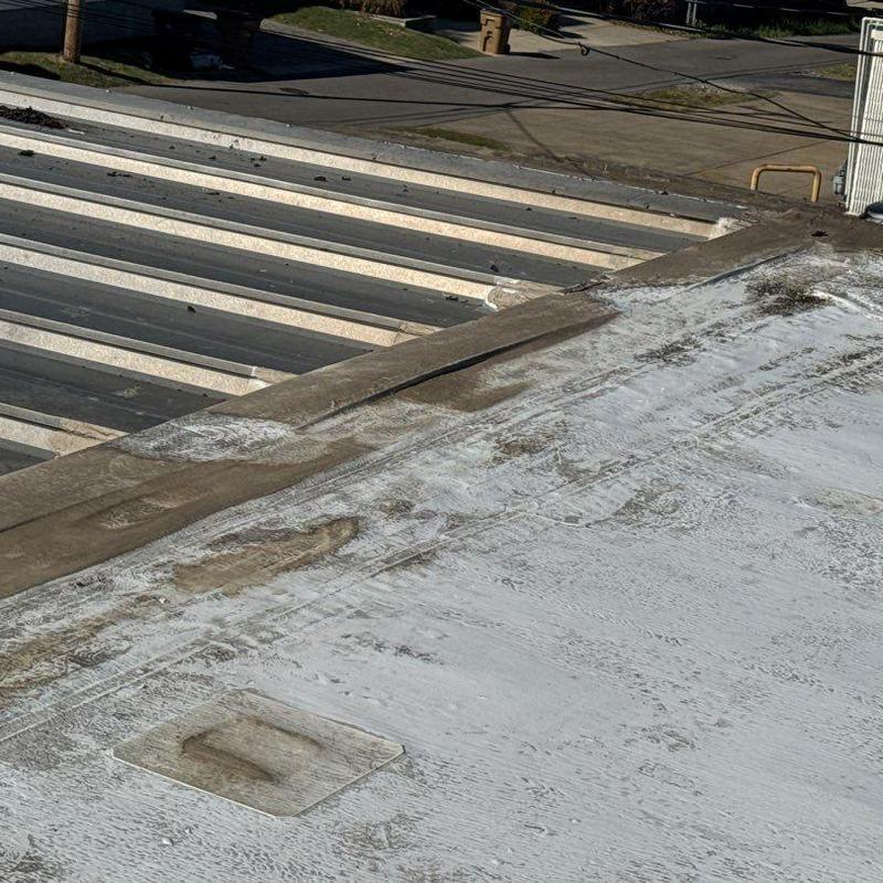 Commercial roof membrane with hail damage and debris