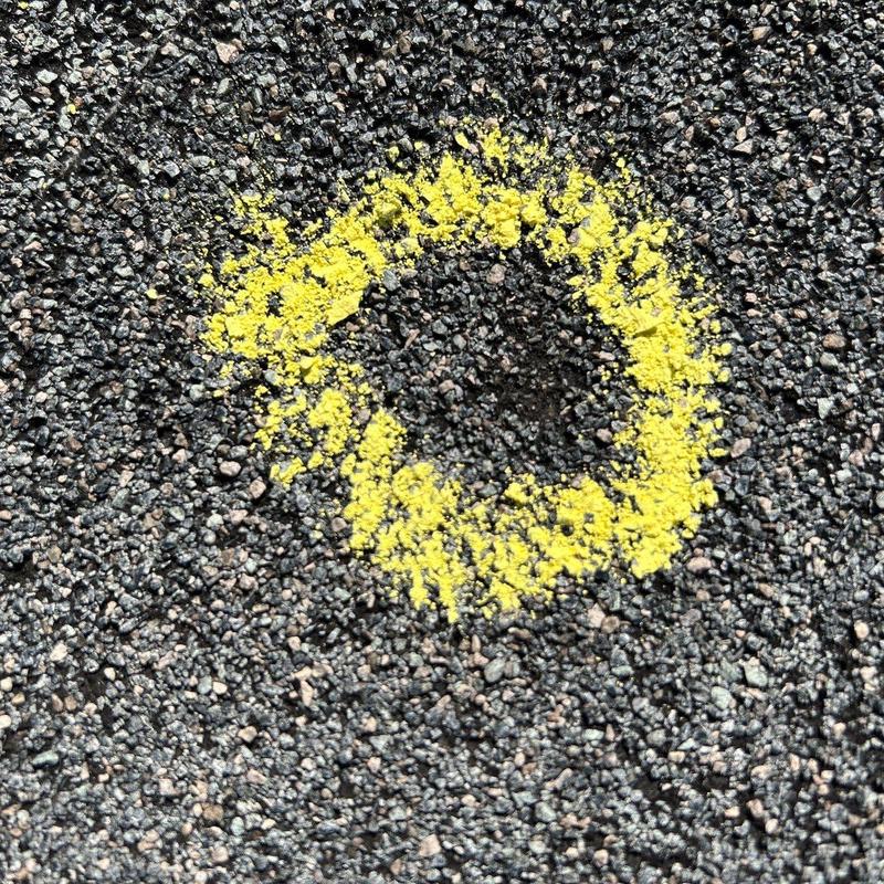 Asphalt shingle hail damage circled with yellow chalk