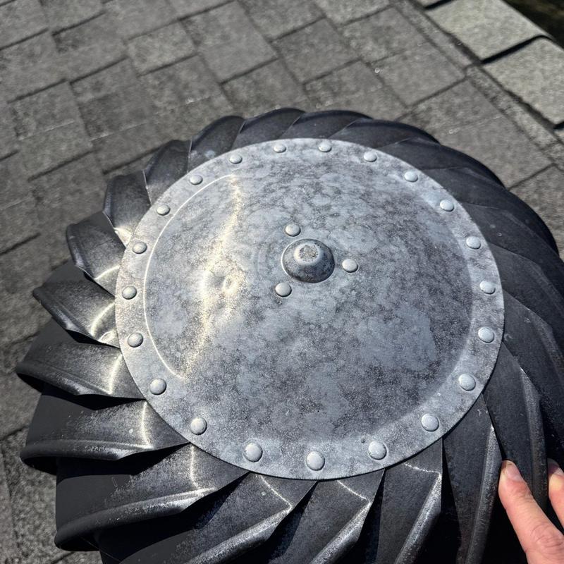 Metal roof turbine vent showing surface wear and dents
