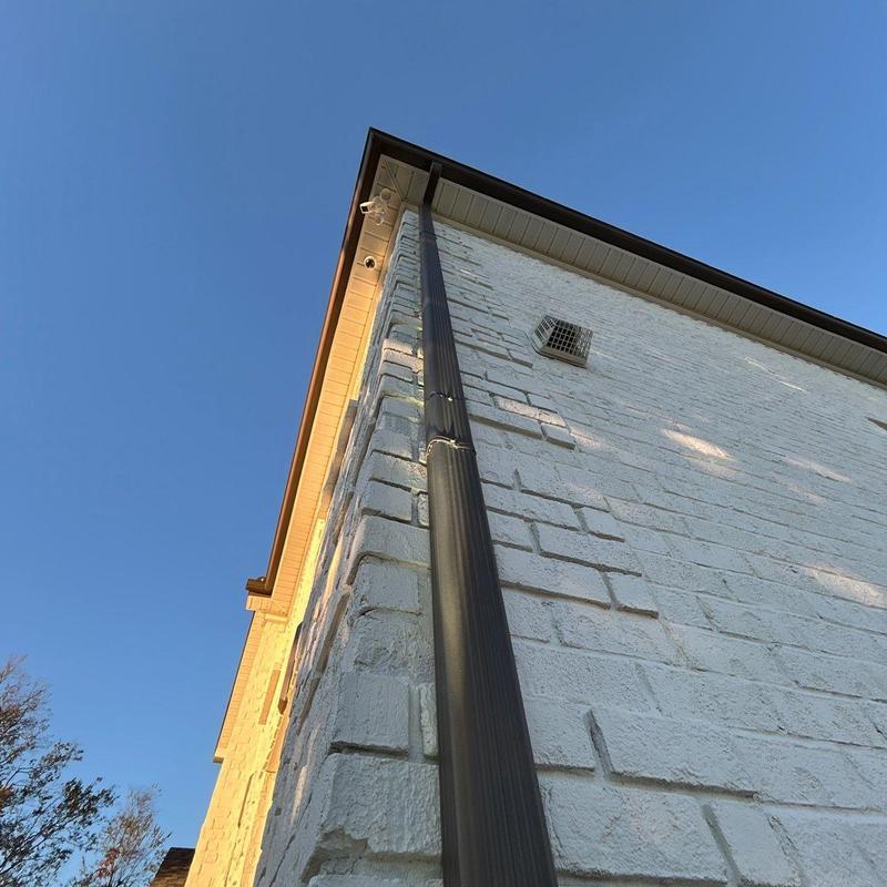 Gutter downspout and white brick exterior wall