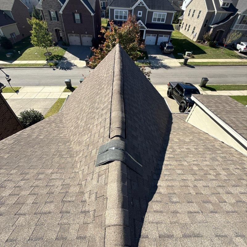 Asphalt roof ridge shingles and metal flashing inspection view