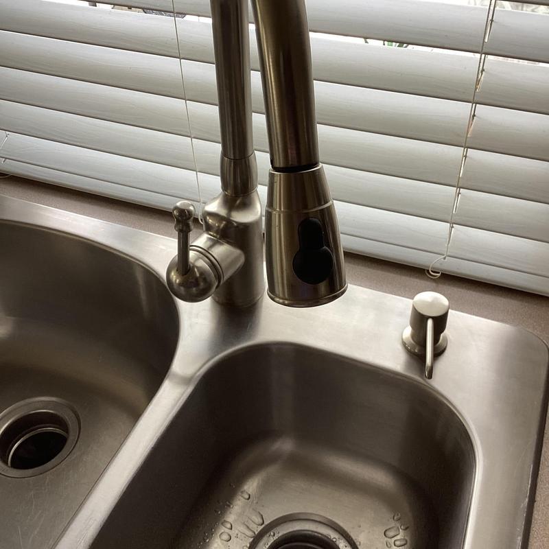 Kitchen sink faucet with hard water buildup and drip