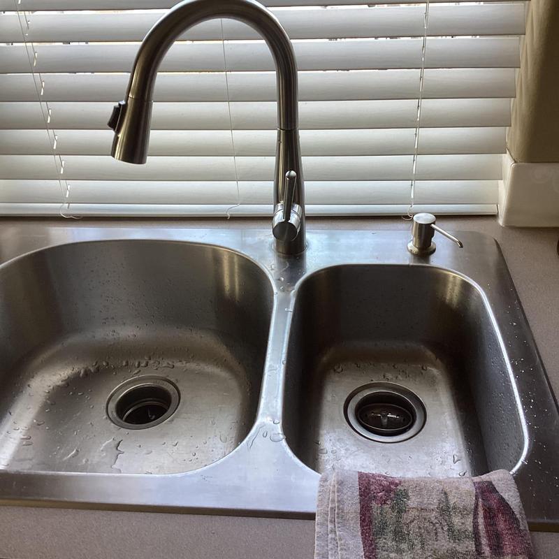 Kitchen faucet with hard water buildup before replacement
