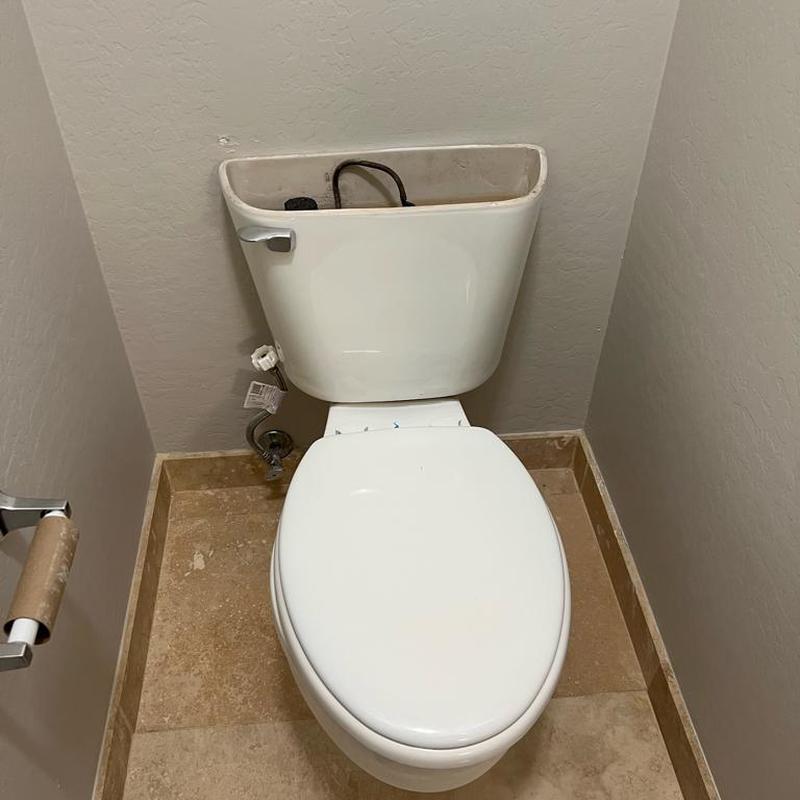 Toilet with tank removed for flange replacement in bathroom