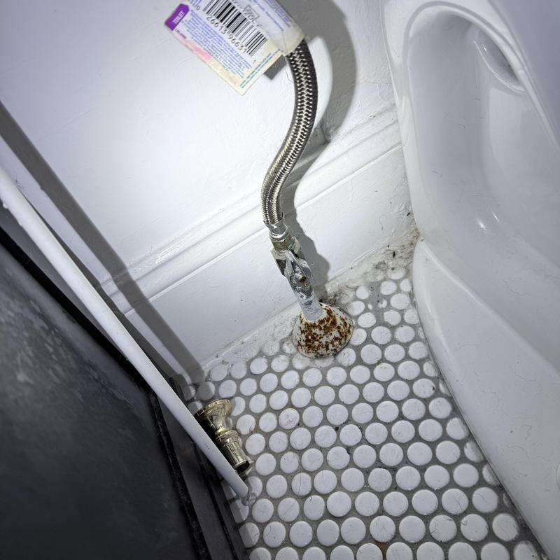 Toilet emergency stop valve with rusted base near floor Toilet emergency stop valve with rusted base near floor