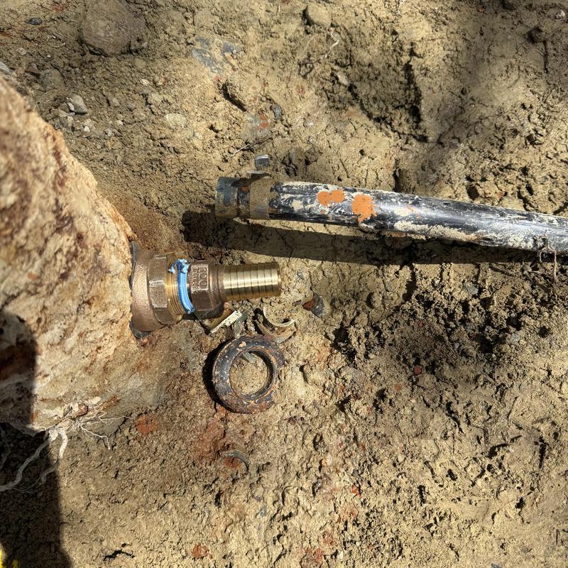 Well pump hose connection with fittings in dirt ground Well pump hose connection with fittings in dirt ground