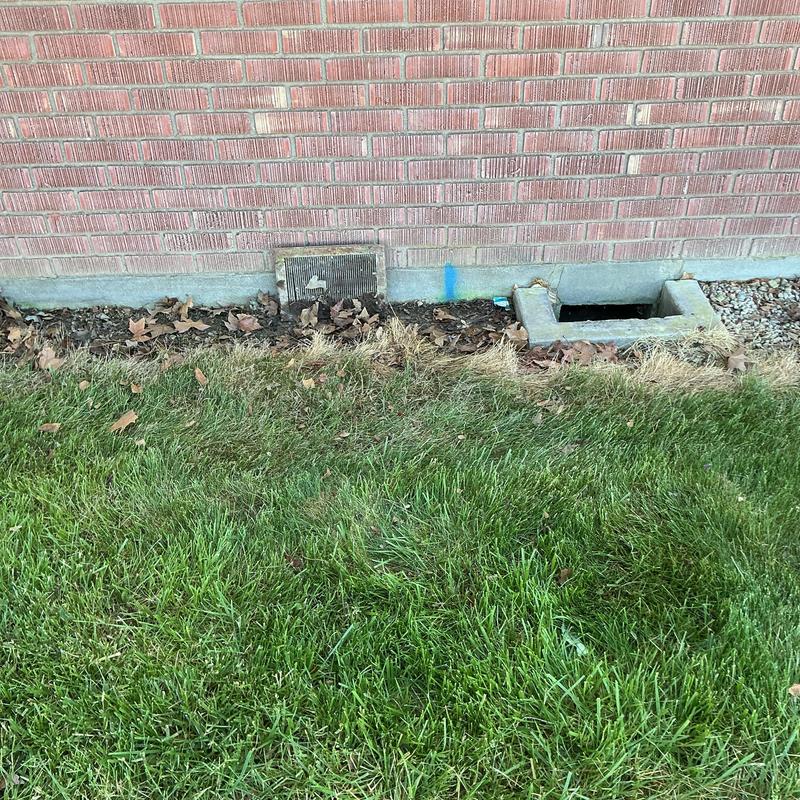 Outside cleanout sewer line with brick wall and grass Outside cleanout sewer line with brick wall and grass