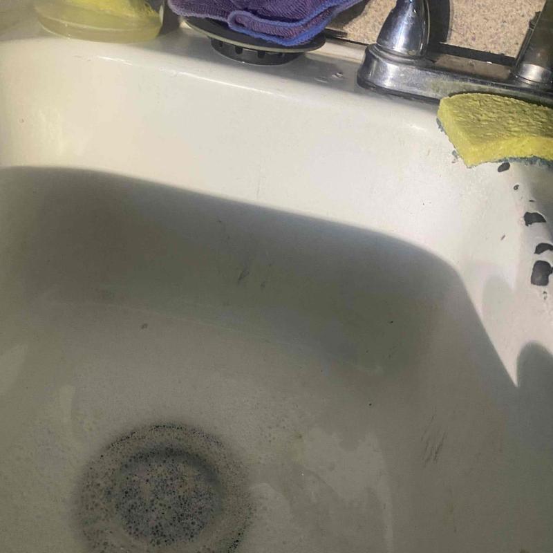 Kitchen sink drain with standing water and soap residue