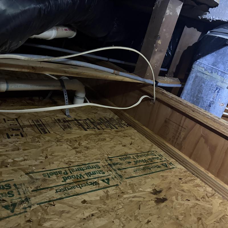 Kitchen sink drain pipe with snake cable in crawlspace