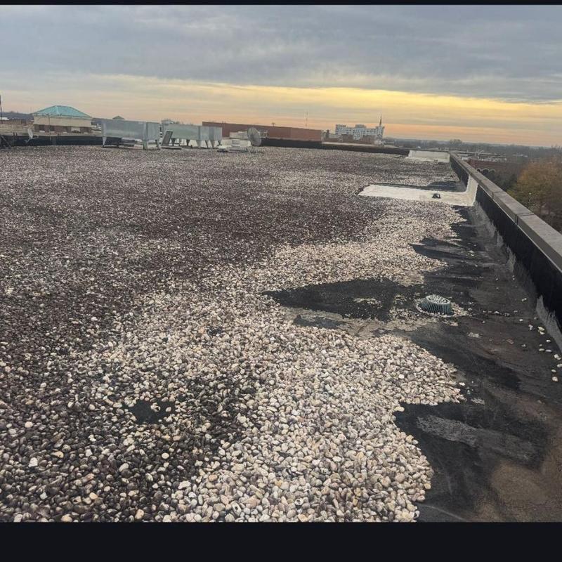 Gravel-covered built-up roof inspection on commercial building Gravel-covered built-up roof inspection on commercial building